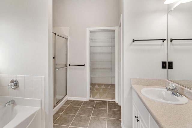 bathroom featuring vanity, a shower stall, a spacious closet, and tile patterned floors