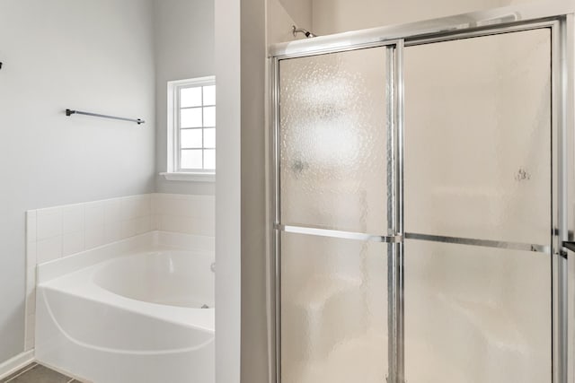 bathroom featuring tile patterned floors, a shower stall, and a garden tub