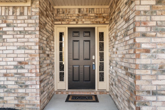 entrance to property featuring brick siding