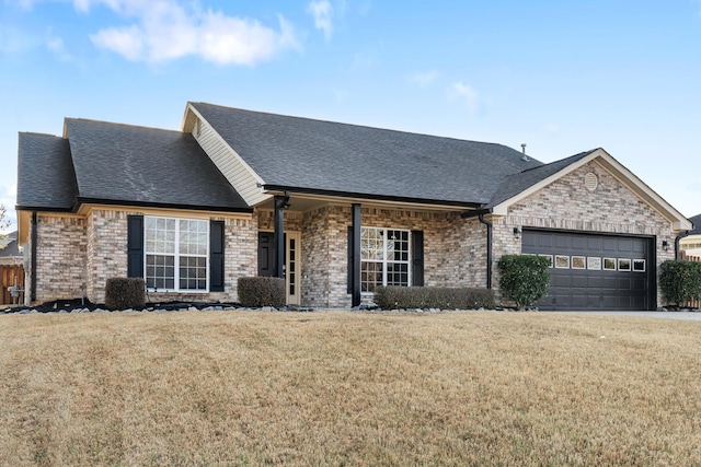 view of front facade featuring a garage, brick siding, a front lawn, and a shingled roof