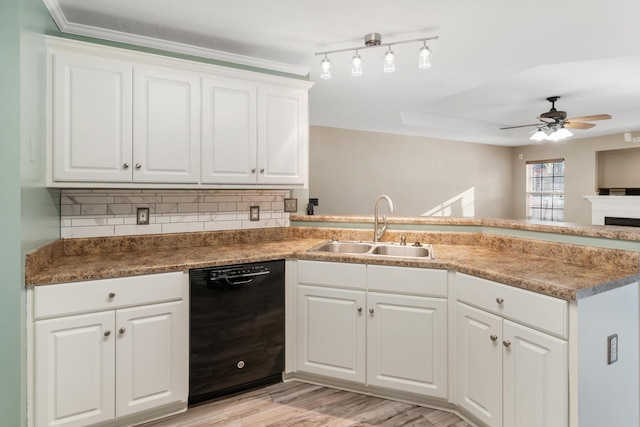 kitchen featuring a sink, tasteful backsplash, black dishwasher, a peninsula, and white cabinets