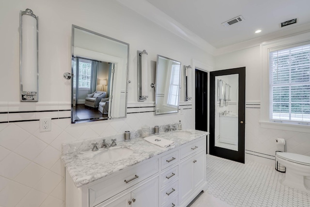 3406 W Richland Ave, Aiken, SC 29801 - full bath featuring tile walls, double vanity, tile patterned flooring, and a wainscoted wall