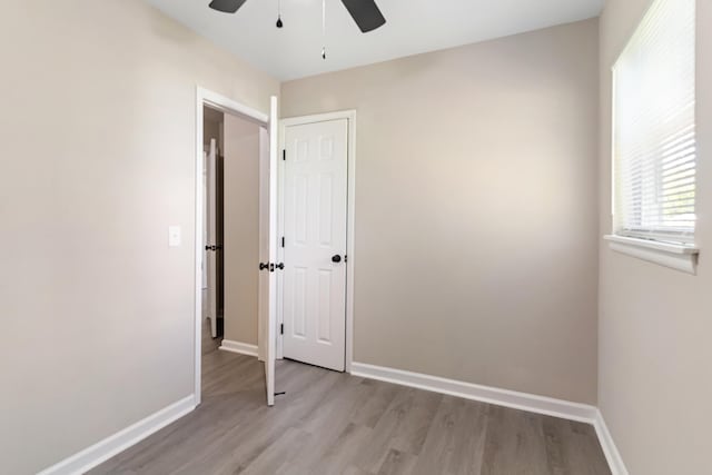 unfurnished bedroom featuring light wood-style flooring, baseboards, and a ceiling fan