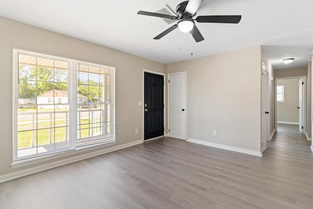 unfurnished living room with baseboards and wood finished floors