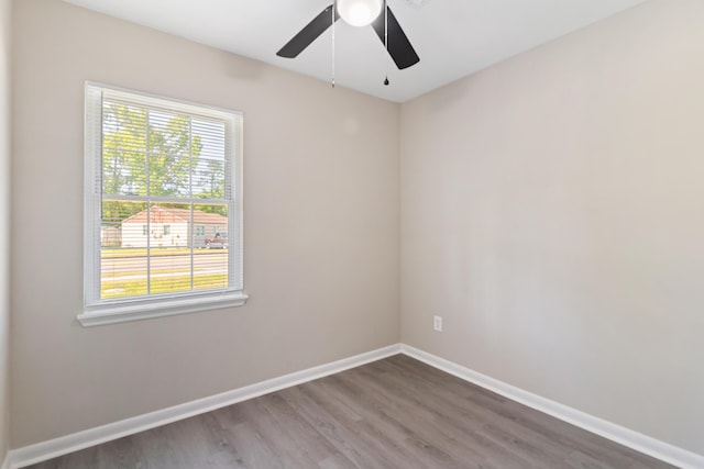 empty room with wood finished floors, ceiling fan, and baseboards