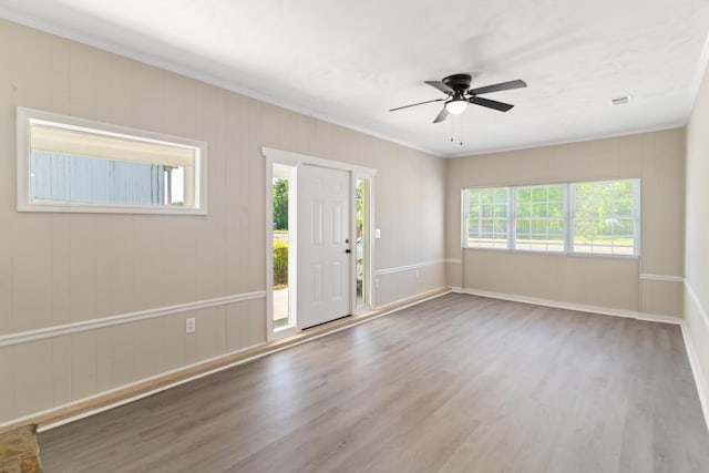 foyer with a ceiling fan, wood finished floors, baseboards, and ornamental molding