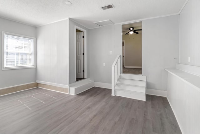 spare room with ornamental molding, wood finished floors, and a textured ceiling