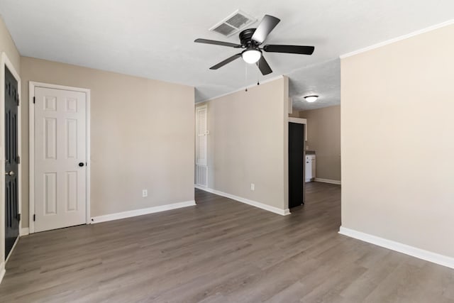 spare room with visible vents, baseboards, a ceiling fan, and wood finished floors