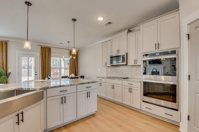 kitchen with decorative backsplash, light stone countertops, double wall oven, pendant lighting, and white cabinetry