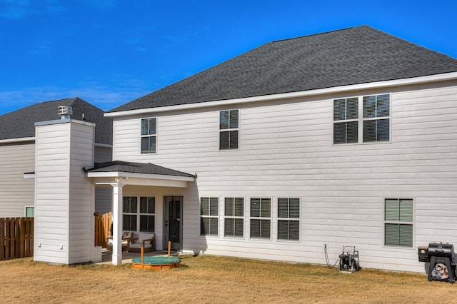 rear view of property featuring a lawn