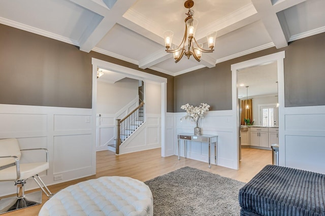 sitting room featuring coffered ceiling, ornamental molding, beamed ceiling, light hardwood / wood-style floors, and a chandelier