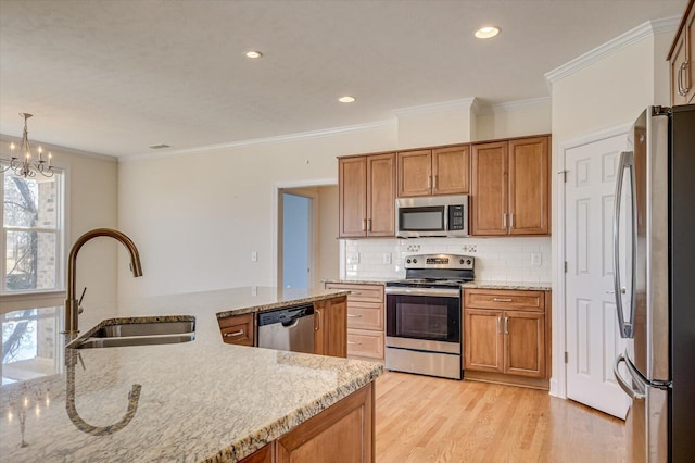 kitchen featuring a sink, brown cabinetry, light wood-style floors, and stainless steel appliances