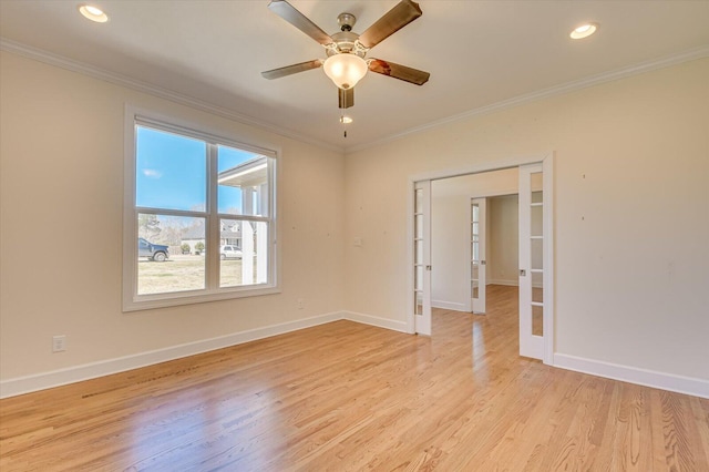 empty room featuring french doors, crown molding, and light wood-style flooring