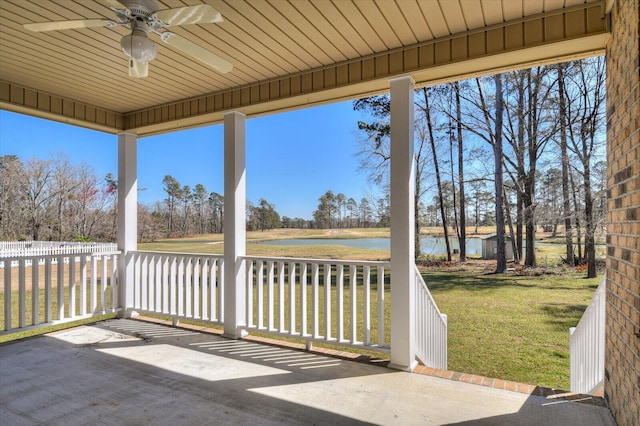 unfurnished sunroom with a water view and a ceiling fan