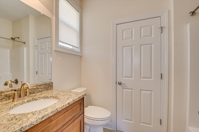 full bathroom featuring toilet, a shower, and vanity