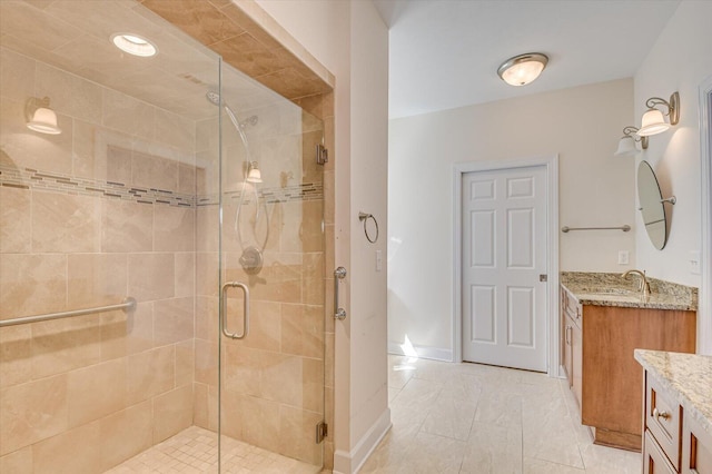 bathroom featuring baseboards, vanity, and a shower stall