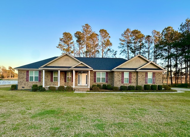 view of front of home featuring a front yard, crawl space, brick siding, and roof with shingles