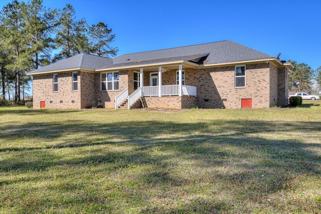 rear view of house featuring brick siding, a yard, roof with shingles, covered porch, and crawl space