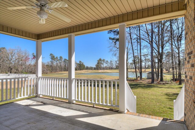 view of patio featuring an outbuilding, a ceiling fan, and a water view
