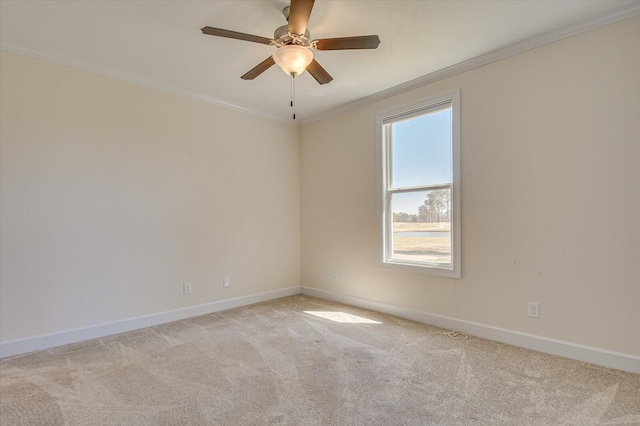 spare room featuring ceiling fan, baseboards, crown molding, and light colored carpet