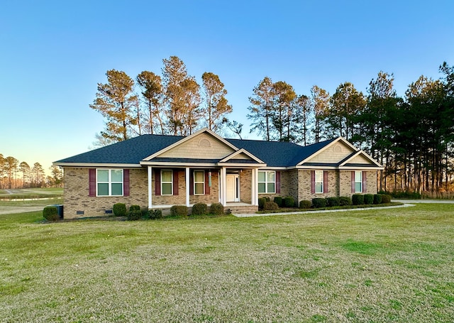 view of front of home featuring roof with shingles, a front lawn, crawl space, and brick siding