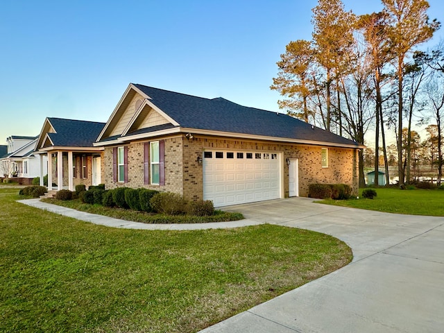 view of side of property with an attached garage, brick siding, a shingled roof, concrete driveway, and a lawn