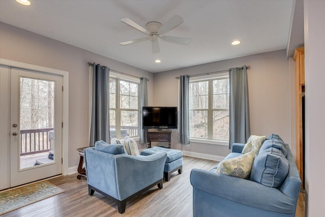 living area featuring a wealth of natural light, light wood-style flooring, and baseboards