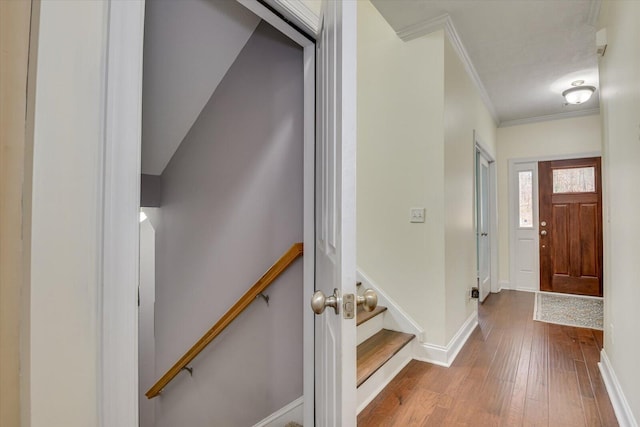 entryway featuring ornamental molding, wood finished floors, and baseboards