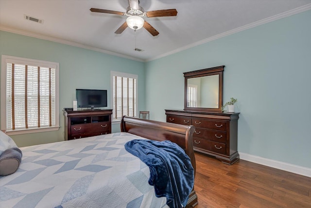 bedroom with crown molding, multiple windows, visible vents, and wood finished floors