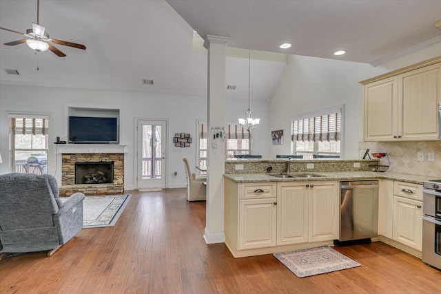 kitchen with cream cabinets, a sink, visible vents, open floor plan, and appliances with stainless steel finishes