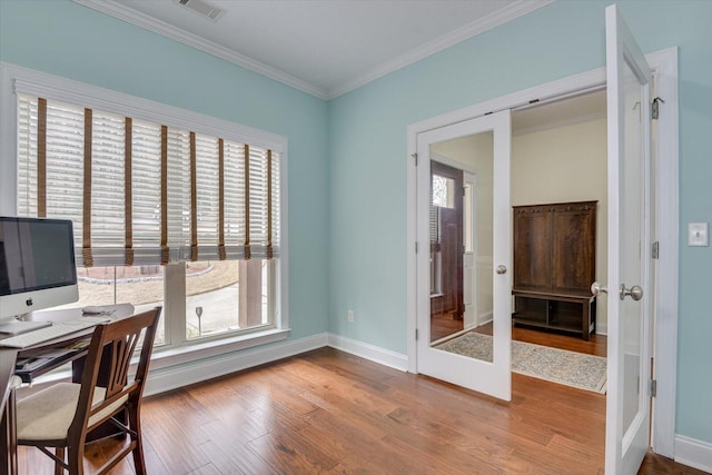 home office with baseboards, visible vents, wood finished floors, crown molding, and french doors