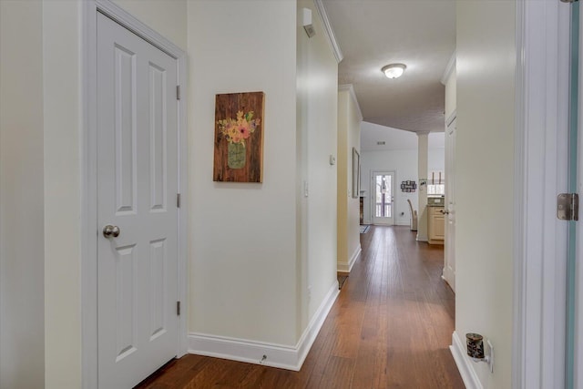 hallway featuring baseboards and dark wood-style flooring