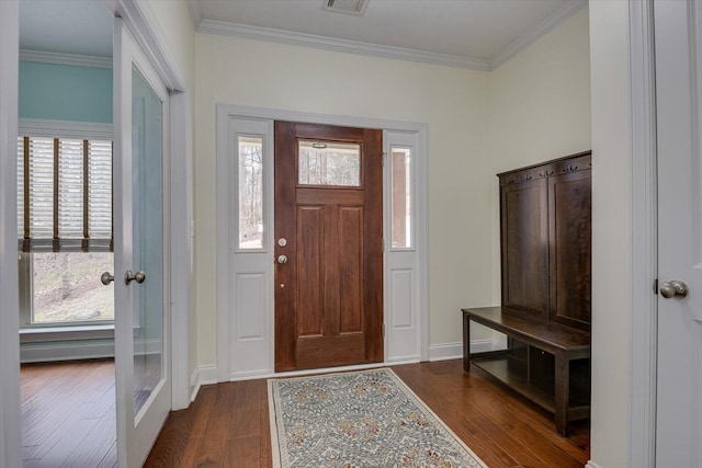 foyer entrance with dark wood-style floors, ornamental molding, and baseboards