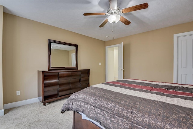 bedroom featuring a ceiling fan, light carpet, and baseboards