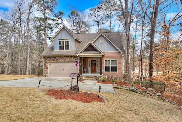 craftsman-style home with concrete driveway, stone siding, an attached garage, a front lawn, and board and batten siding