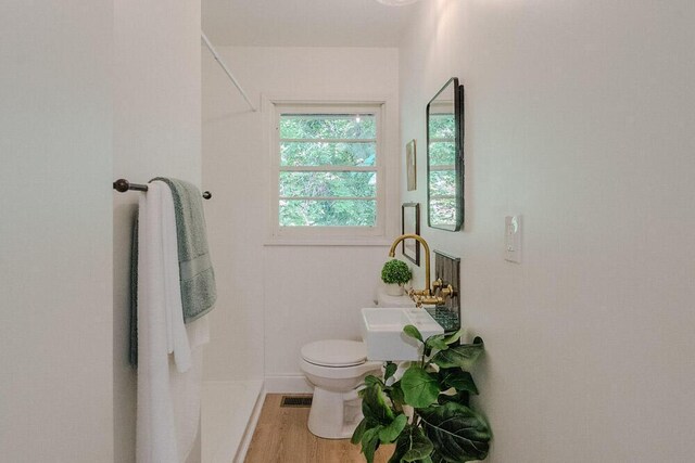 115 W St, Thomson, GA 30824 - bathroom featuring toilet, wood finished floors, and baseboards