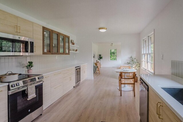 115 W St, Thomson, GA 30824 - kitchen with appliances with stainless steel finishes, wine cooler, light wood-style floors, decorative backsplash, and light countertops