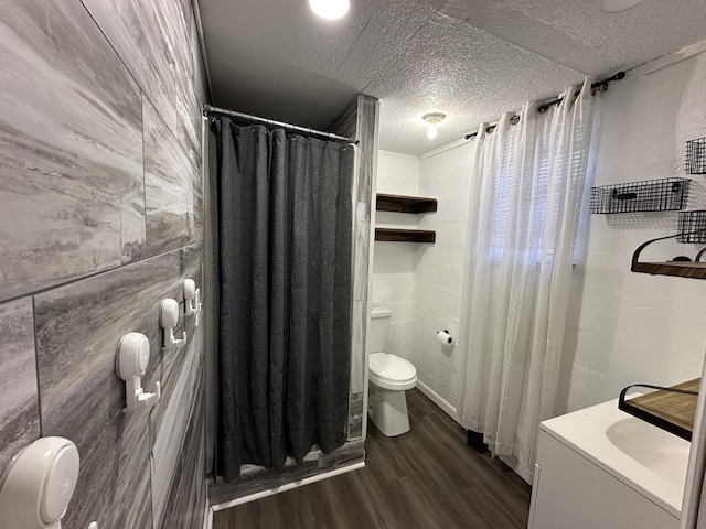 bathroom with hardwood / wood-style floors, vanity, a textured ceiling, a shower with curtain, and toilet