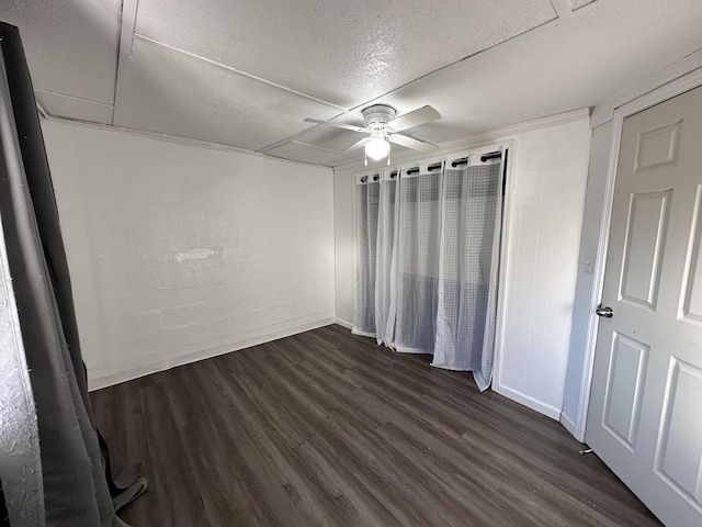 unfurnished bedroom featuring ceiling fan, dark wood-type flooring, and a textured ceiling