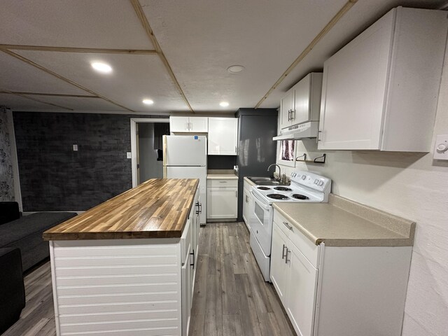 kitchen with sink, white appliances, butcher block counters, wood-type flooring, and white cabinets