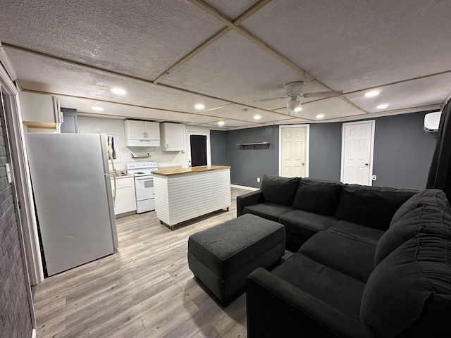 living room with light hardwood / wood-style floors and a wall mounted AC