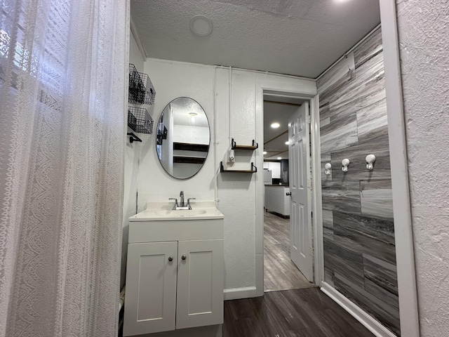 bathroom featuring vanity, wood-type flooring, tile walls, and a textured ceiling