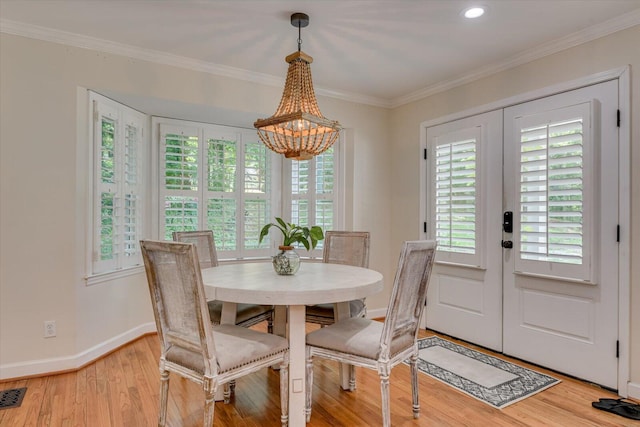 dining area featuring a chandelier, light hardwood / wood-style flooring, and ornamental molding