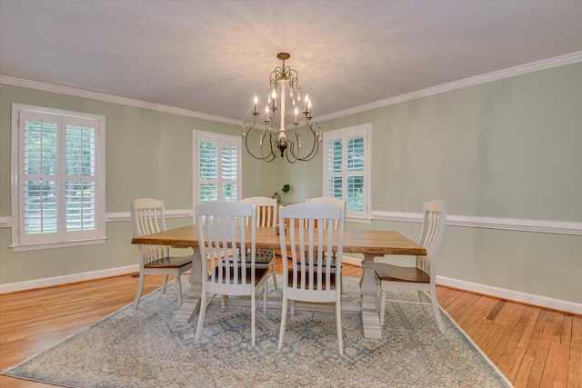 dining area featuring ornamental molding, plenty of natural light, a chandelier, and hardwood / wood-style flooring