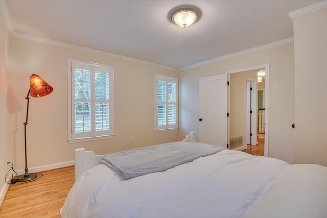 bedroom with light hardwood / wood-style floors and ornamental molding