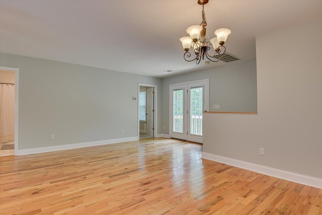 unfurnished room featuring light hardwood / wood-style floors and a chandelier