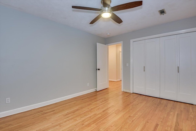 unfurnished bedroom with ceiling fan, light hardwood / wood-style flooring, and a closet