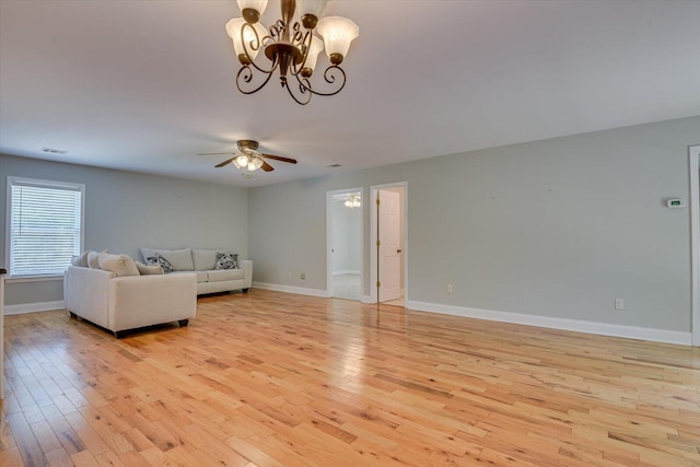 unfurnished living room featuring ceiling fan with notable chandelier and light hardwood / wood-style floors