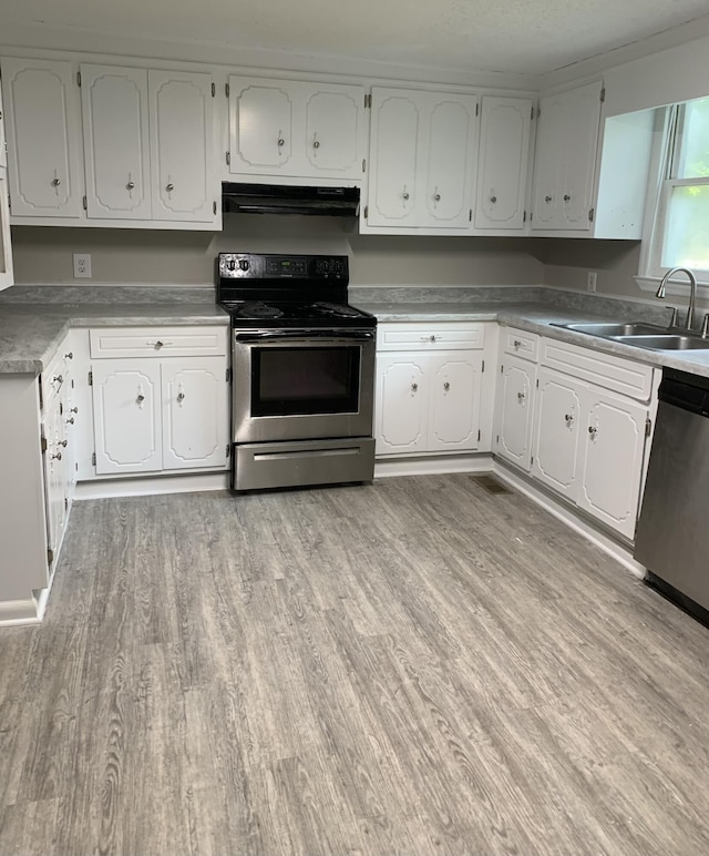 1921 Fenwick St, Augusta, GA 30904 - kitchen featuring appliances with stainless steel finishes, exhaust hood, light wood-style flooring, and white cabinets