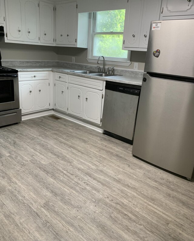 1921 Fenwick St, Augusta, GA 30904 - kitchen featuring appliances with stainless steel finishes, light wood-type flooring, and white cabinets